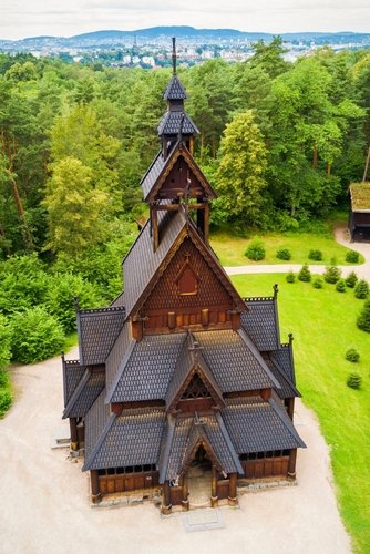 Luchtfoto van Gol Stavkyrkje in Olso, met het bos op de achtergrond en de stad aan de horizon